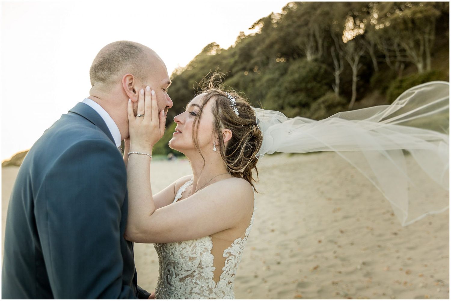 Couple sharing an intimate moment on a scenic beach during sunset.