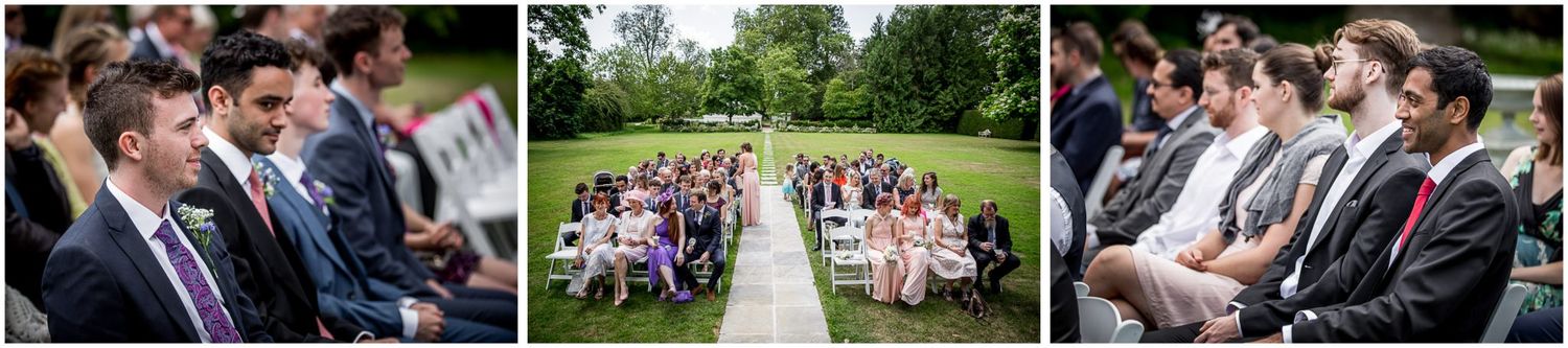 Wedding guests celebrate during an outdoor garden ceremony on a sunny summer day.