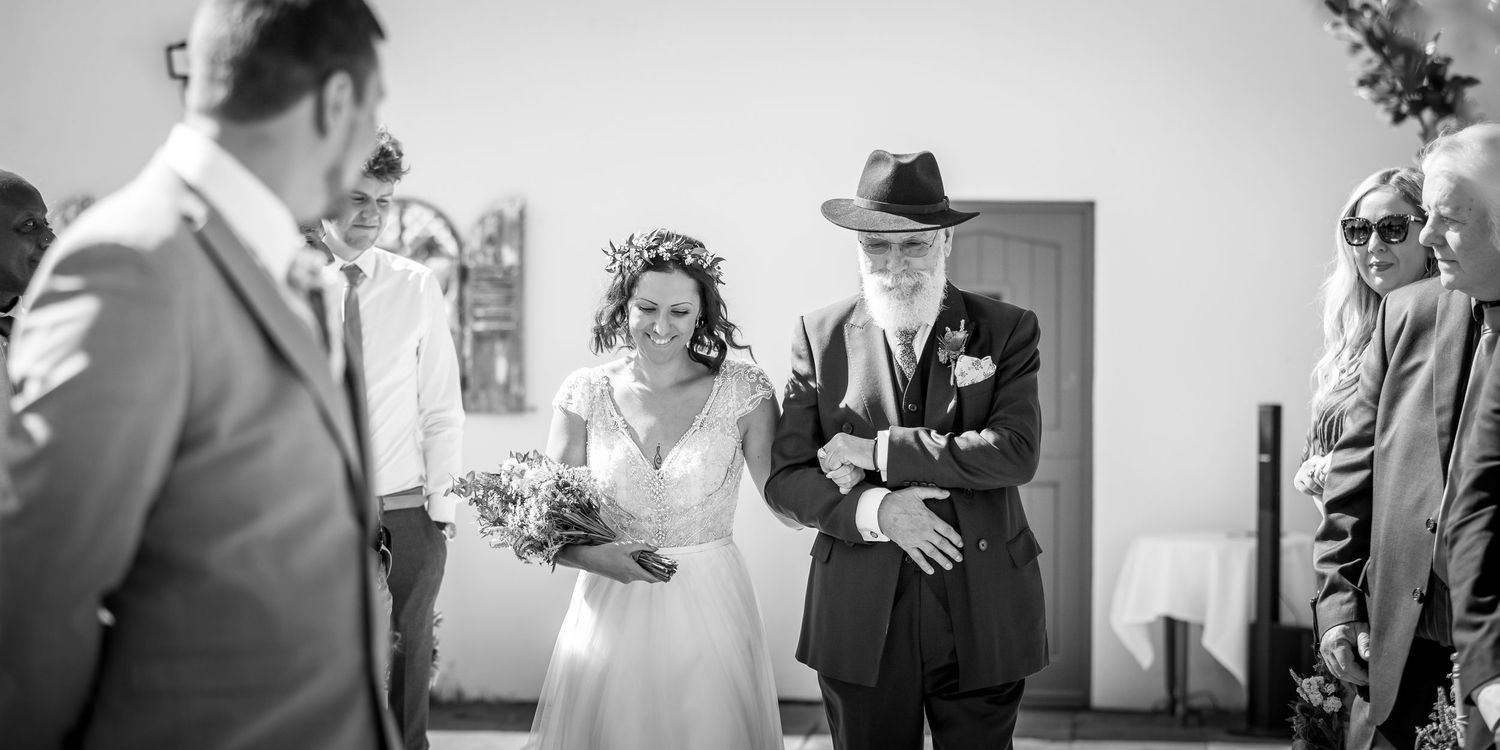 Black and white ceremony photo showing emotional exchange during wedding vows.