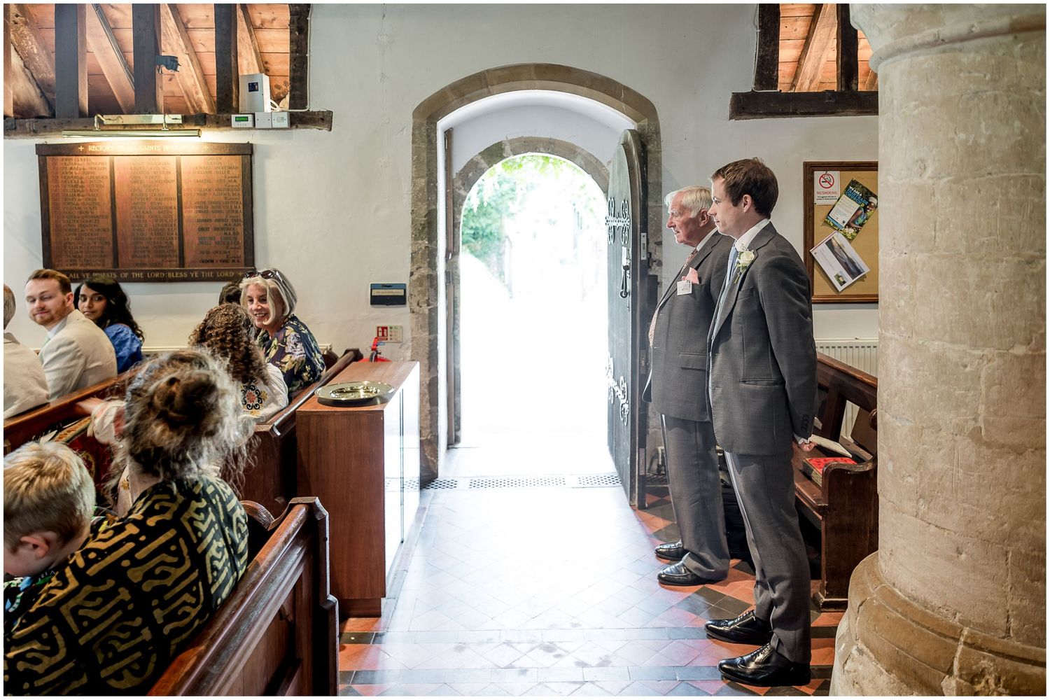 Wedding ceremony processional shots inside historic stone church with arched doorways.