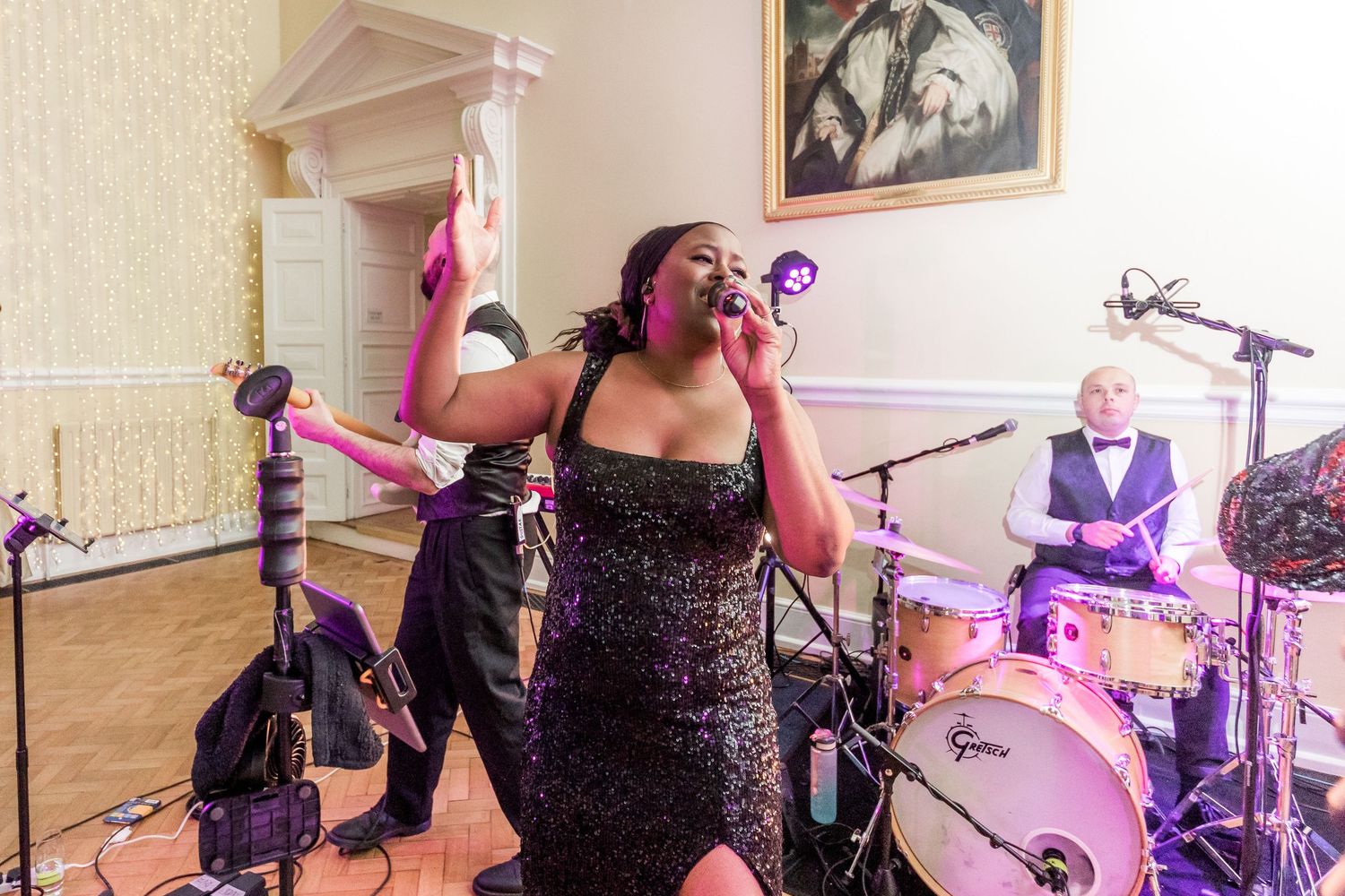 Wedding reception entertainment with band performing on stage under purple lighting.