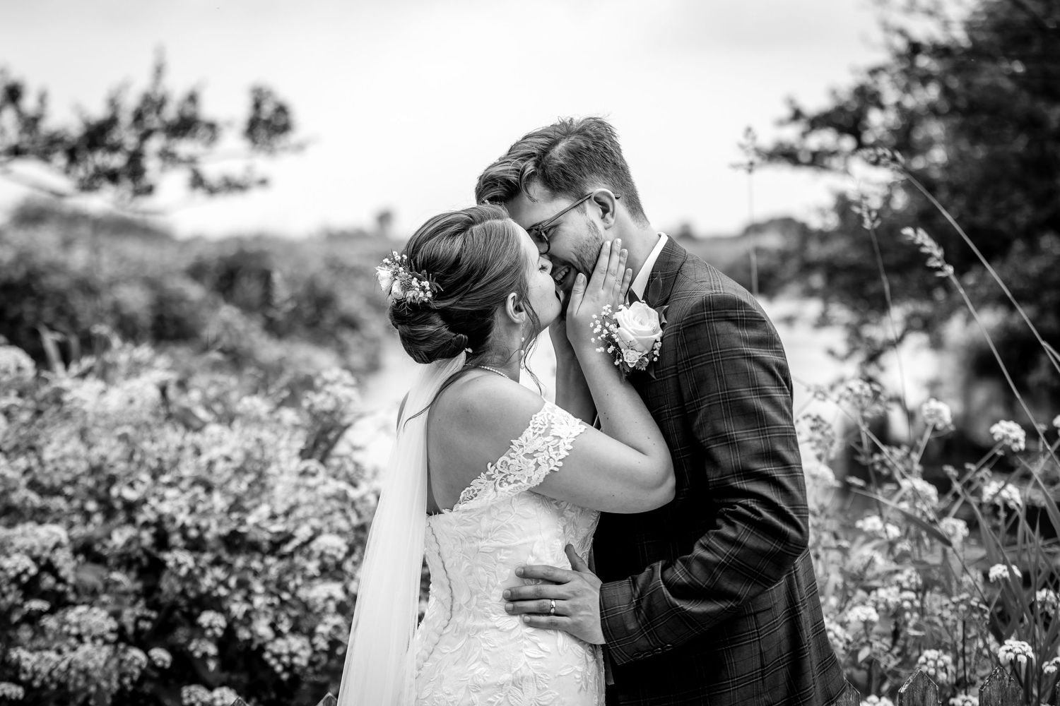Black and white wedding portrait capturing a tender moment between newlyweds.