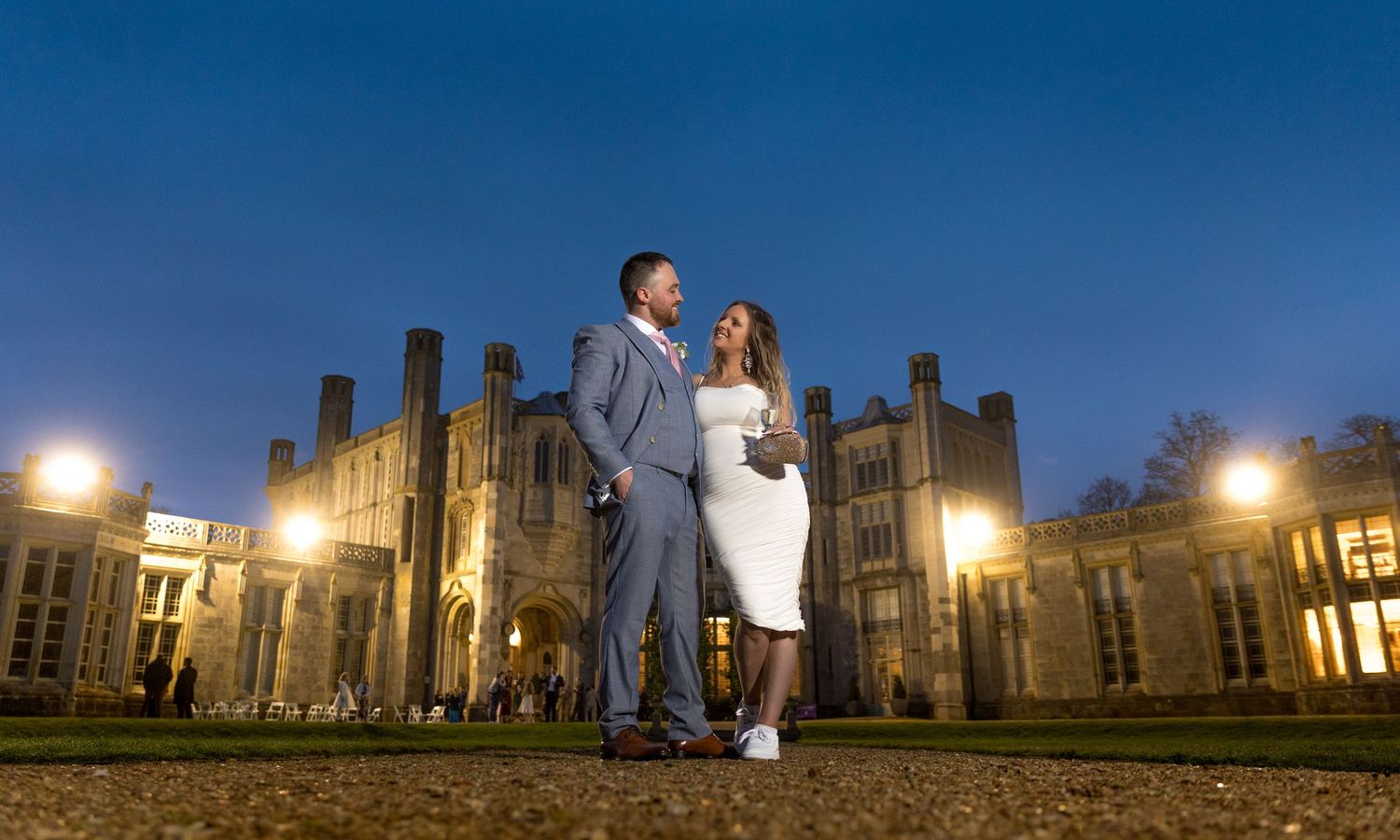 Evening wedding photos at a grand historic castle with dramatic lighting and architecture.