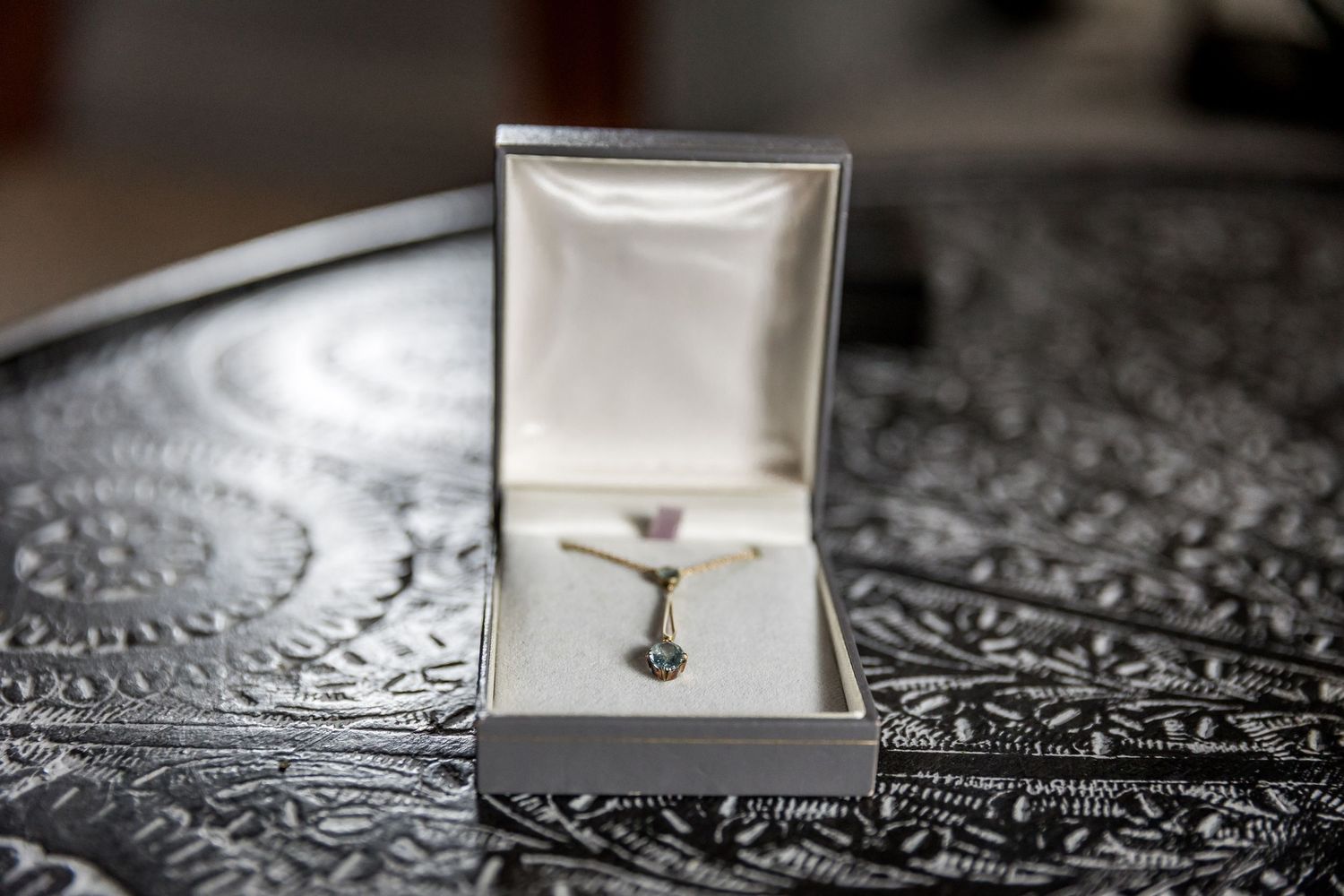 Wedding rings and jewelry boxes arranged on intricate lace pattern surface.