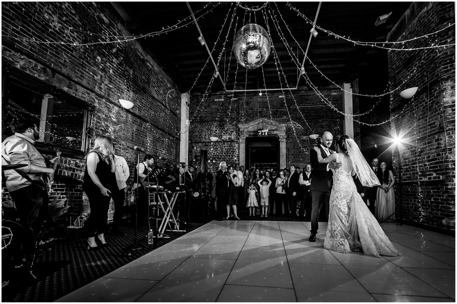 Wedding reception in a rustic venue with string lights creating a magical atmosphere.