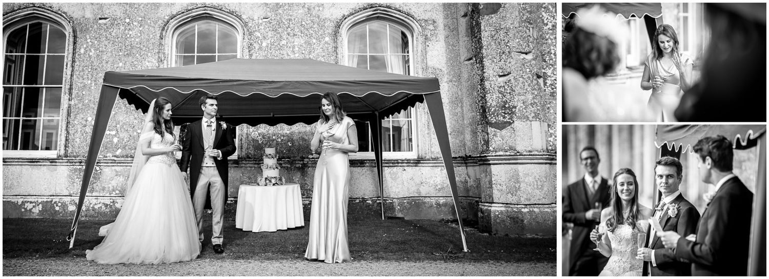 Wedding ceremony participants gather under an outdoor canopy at a stone church on a sunny day.