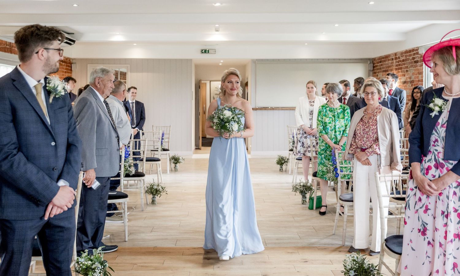 Wide shot of an elegant wedding venue with exposed brick walls and decorative elements.