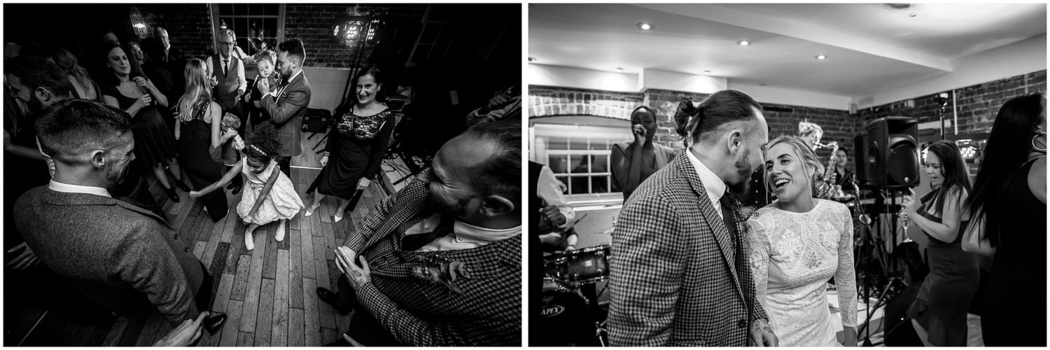 Black and white photo of wedding guests dancing at an indoor reception.
