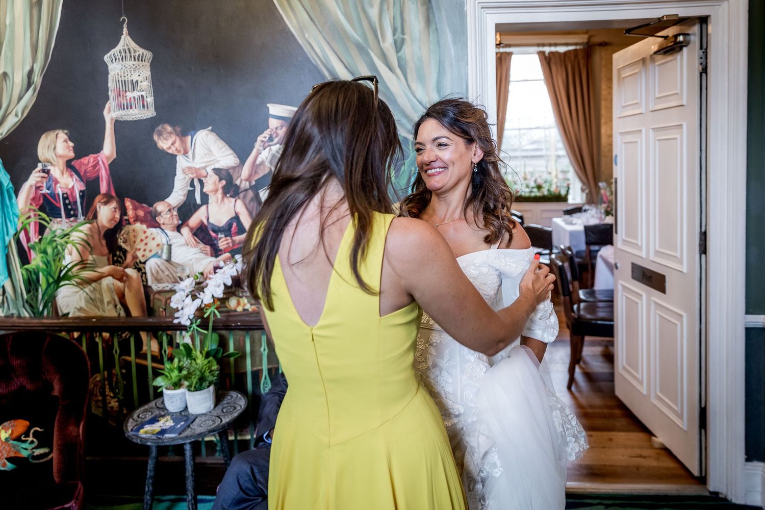 Wedding celebration candid moments in elegant indoor venue with yellow dress.