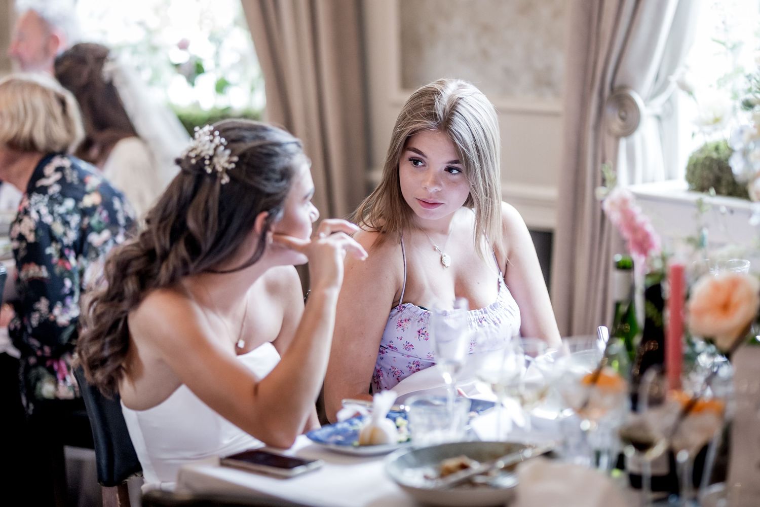 Elegant dining room scene with soft window light and floral decorations.