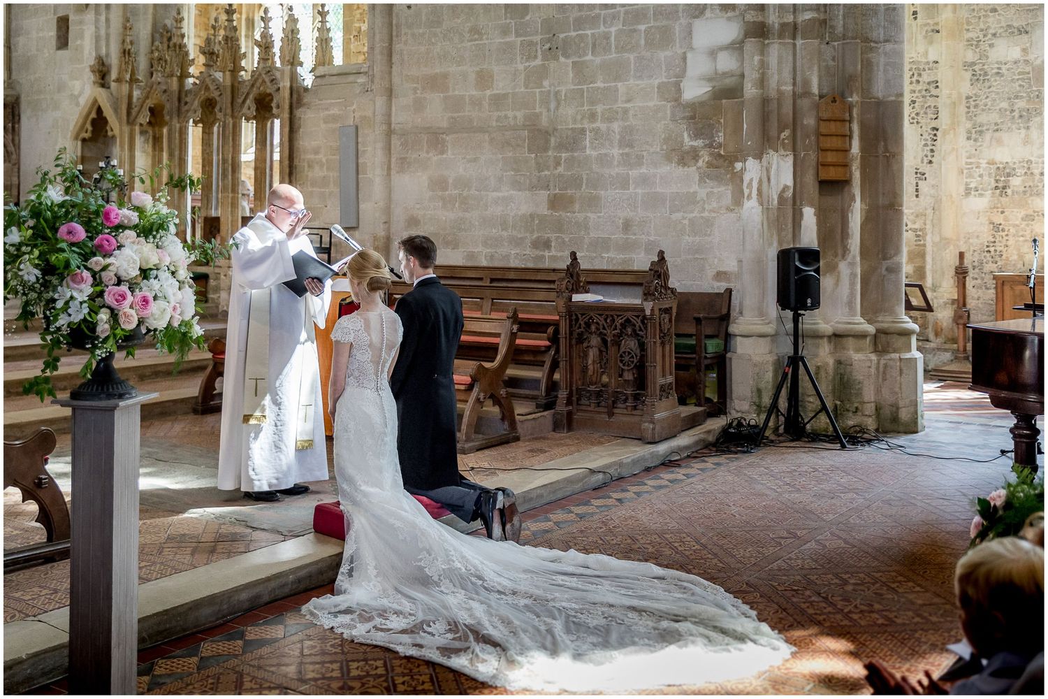 Beautiful stone church interior decorated with floral arrangements for a wedding ceremony.