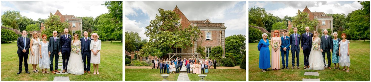 Wedding party poses outdoors on a sunny day in front of a historic brick building and lush green lawn.