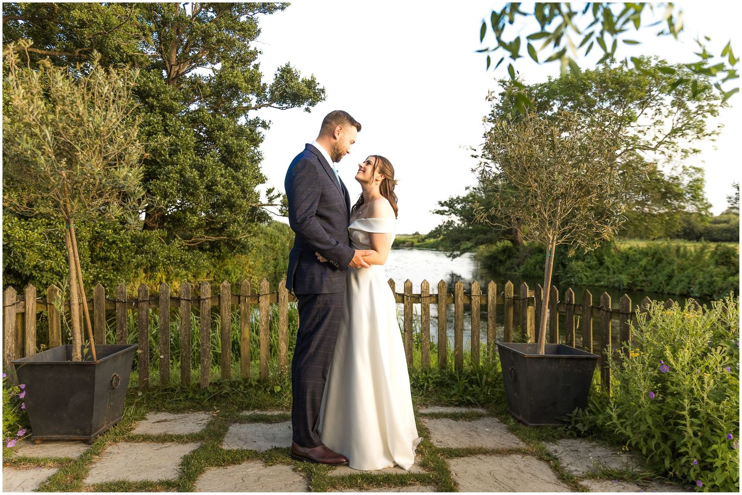Bride and groom wedding portrait at the far end of the grounds at Sopley Mill with views across the river and water meadows