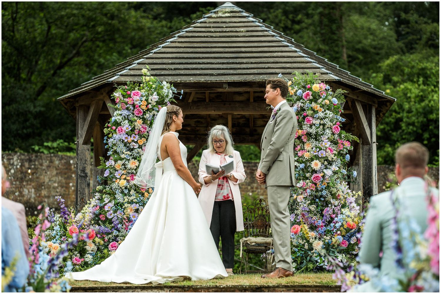 Wedding photography at the Holywell Estate near Winchester with bride and groom stood in front of the gazebo for an outdoor wedding