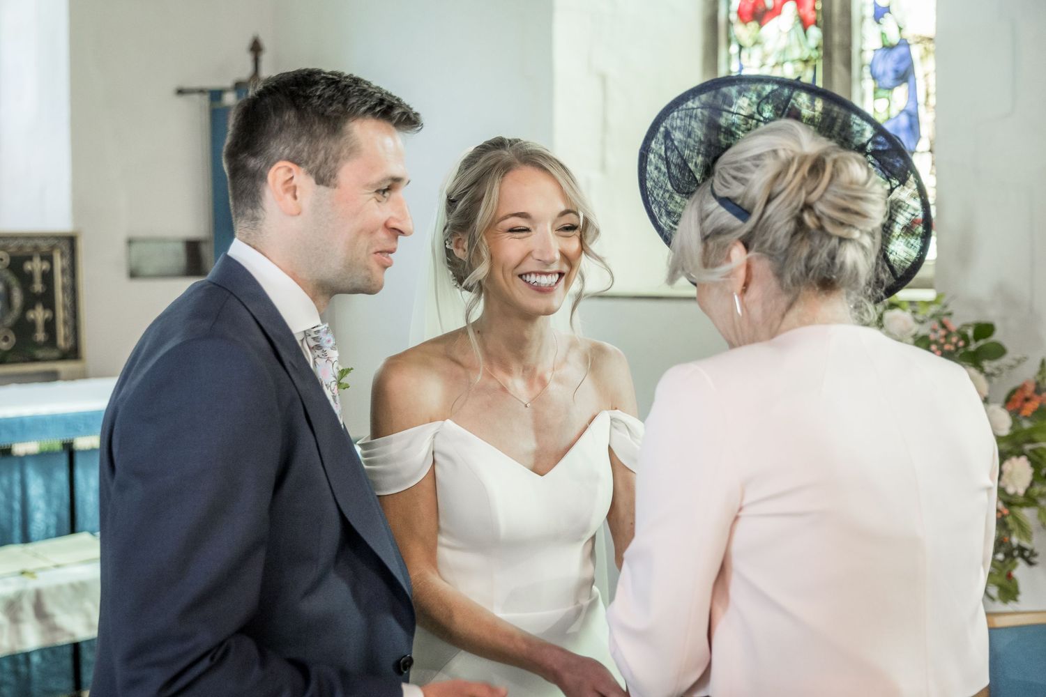 Wedding ceremony moments with stained glass windows in background.