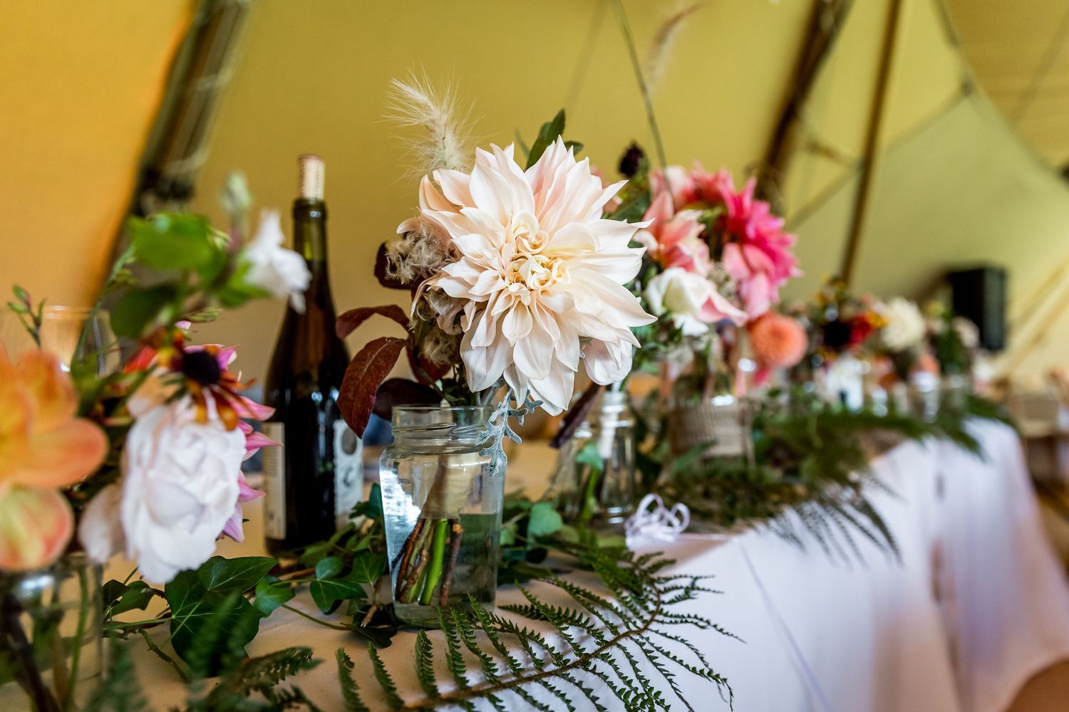 Elegant floral centerpieces with pink and white blooms on reception tables.