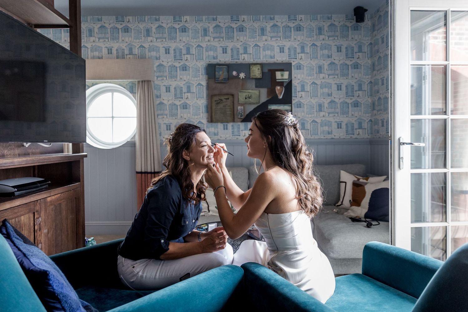 Friends sharing intimate conversations on a blue couch in a bright room.