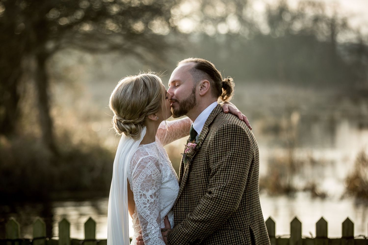 Intimate wedding portraits taken at sunset with dreamy backlit atmosphere.