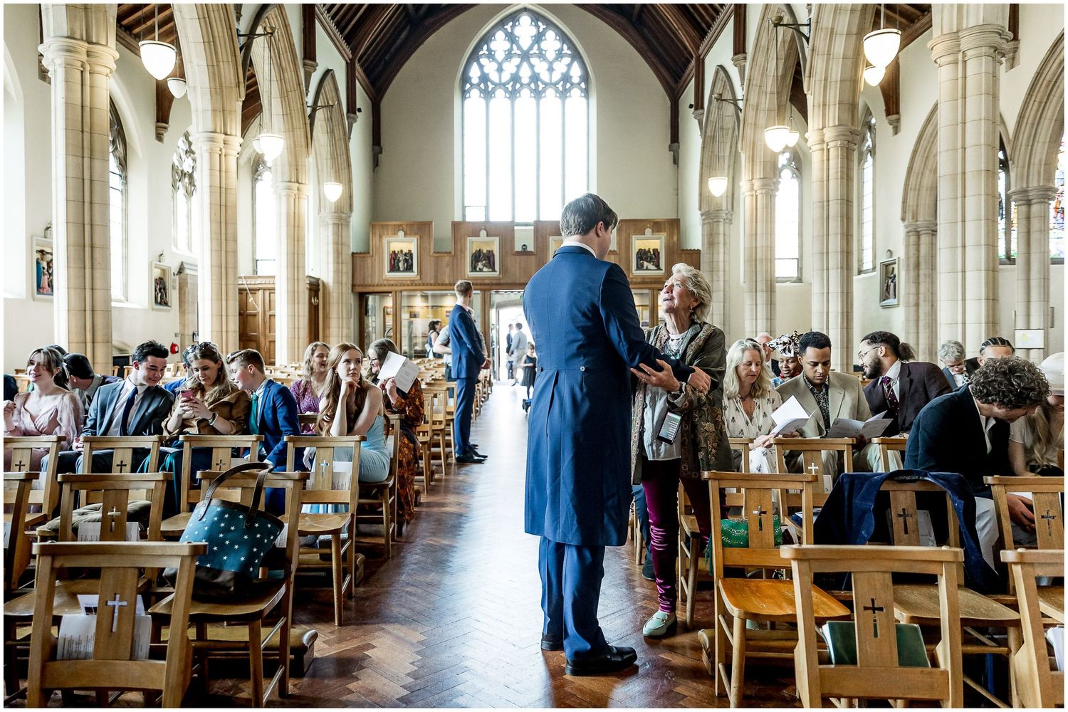 Church interior with wooden pews and gothic architecture during a ceremony.