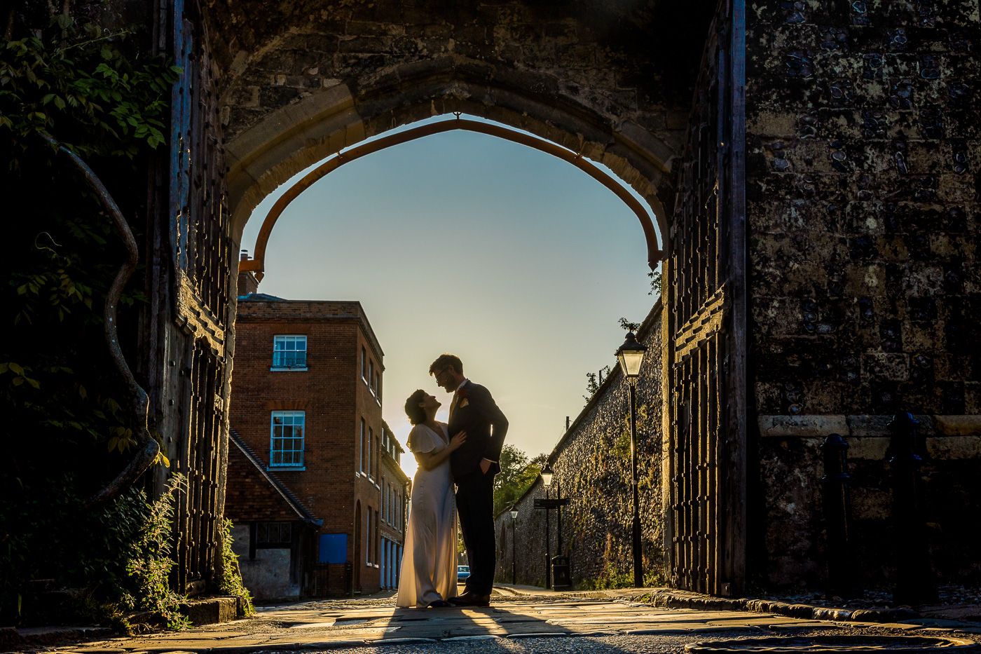 Romantic silhouettes framed by architectural arches at sunset.
