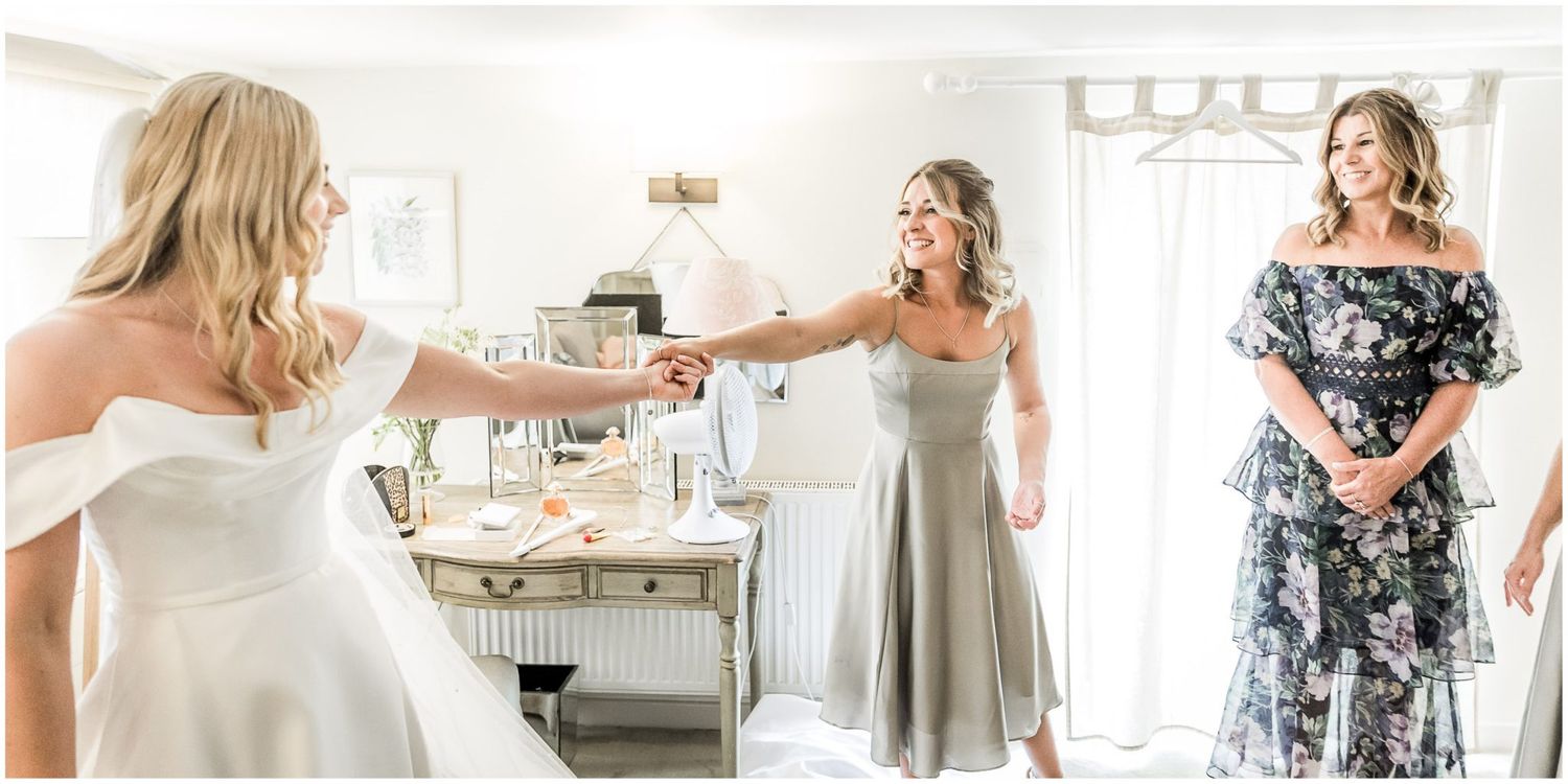 Wedding party in light colored dresses preparing for the ceremony in a bright interior.