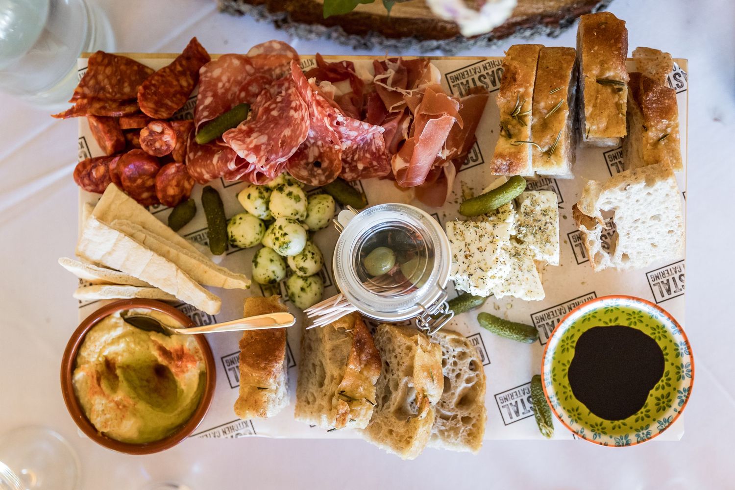 Elegant table settings and appetizers at a wedding reception with rustic decor and natural lighting.