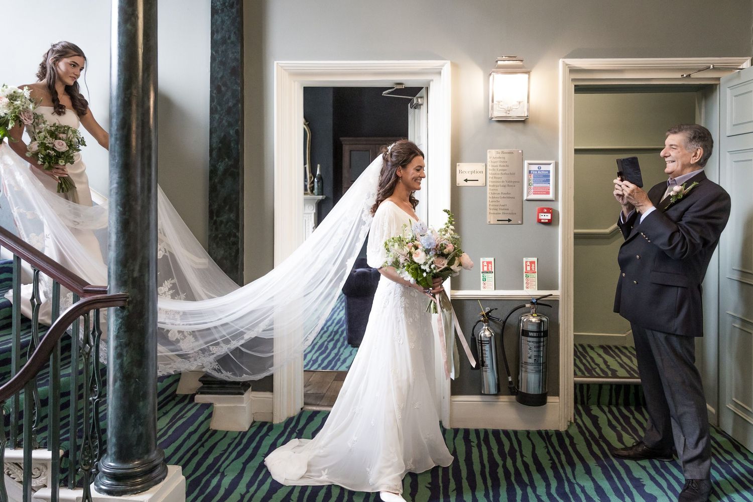 Wedding party ascending and descending an elegant staircase in a historic building.