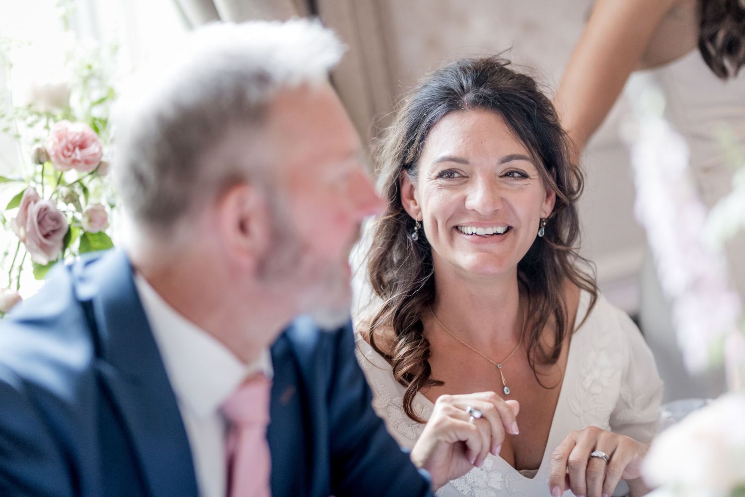 Wedding guests share joyful moments during a celebration at an elegant indoor venue.