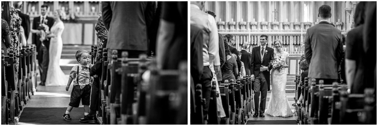 Black and white photo of wedding guests seated in church pews during the ceremony.