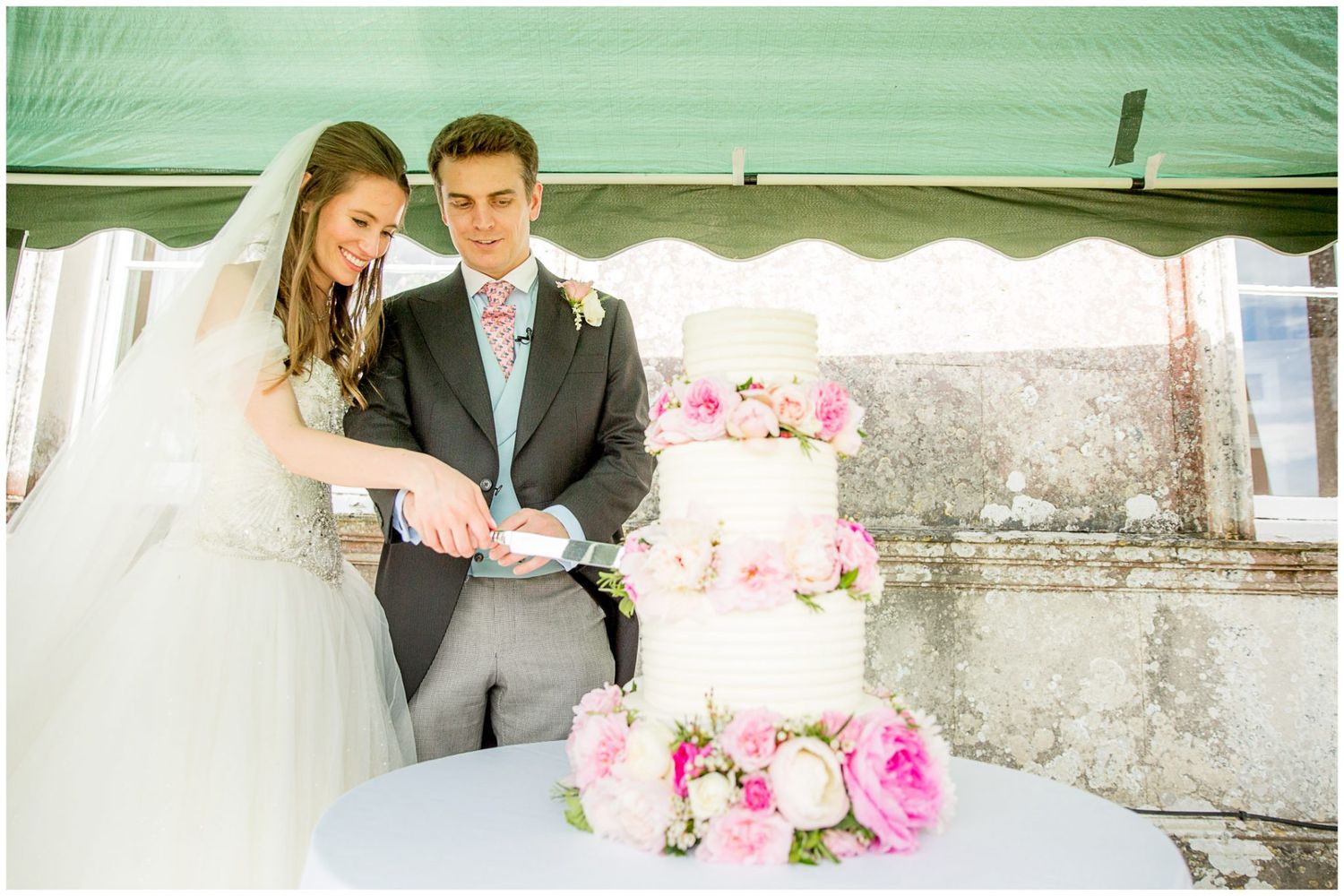 A romantic wedding ceremony scene with pink floral arrangements and elegant decor in an outdoor setting.
