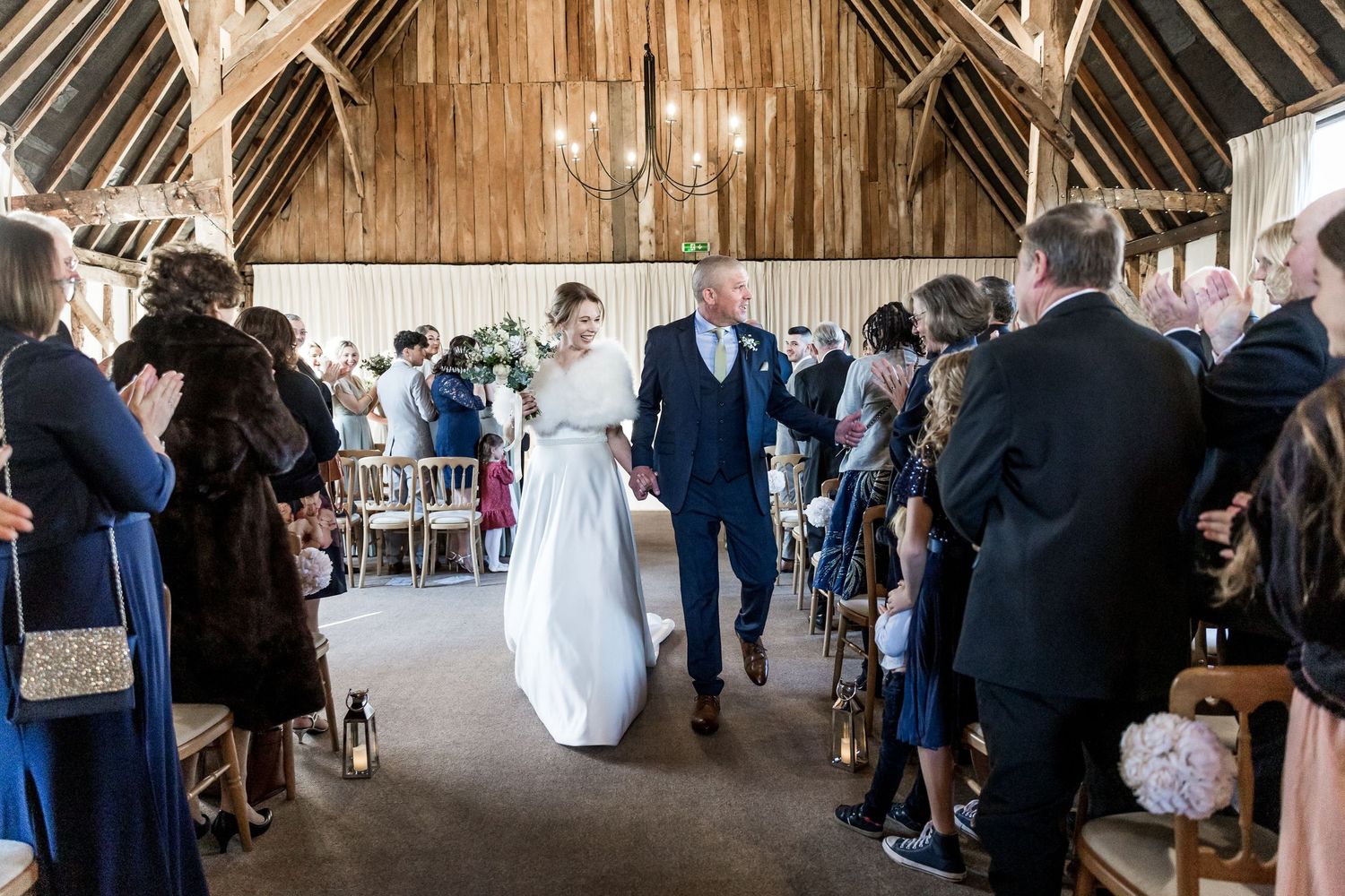 Wedding photograph at Clock Barn with the couple walking down the aisle as husband and wife