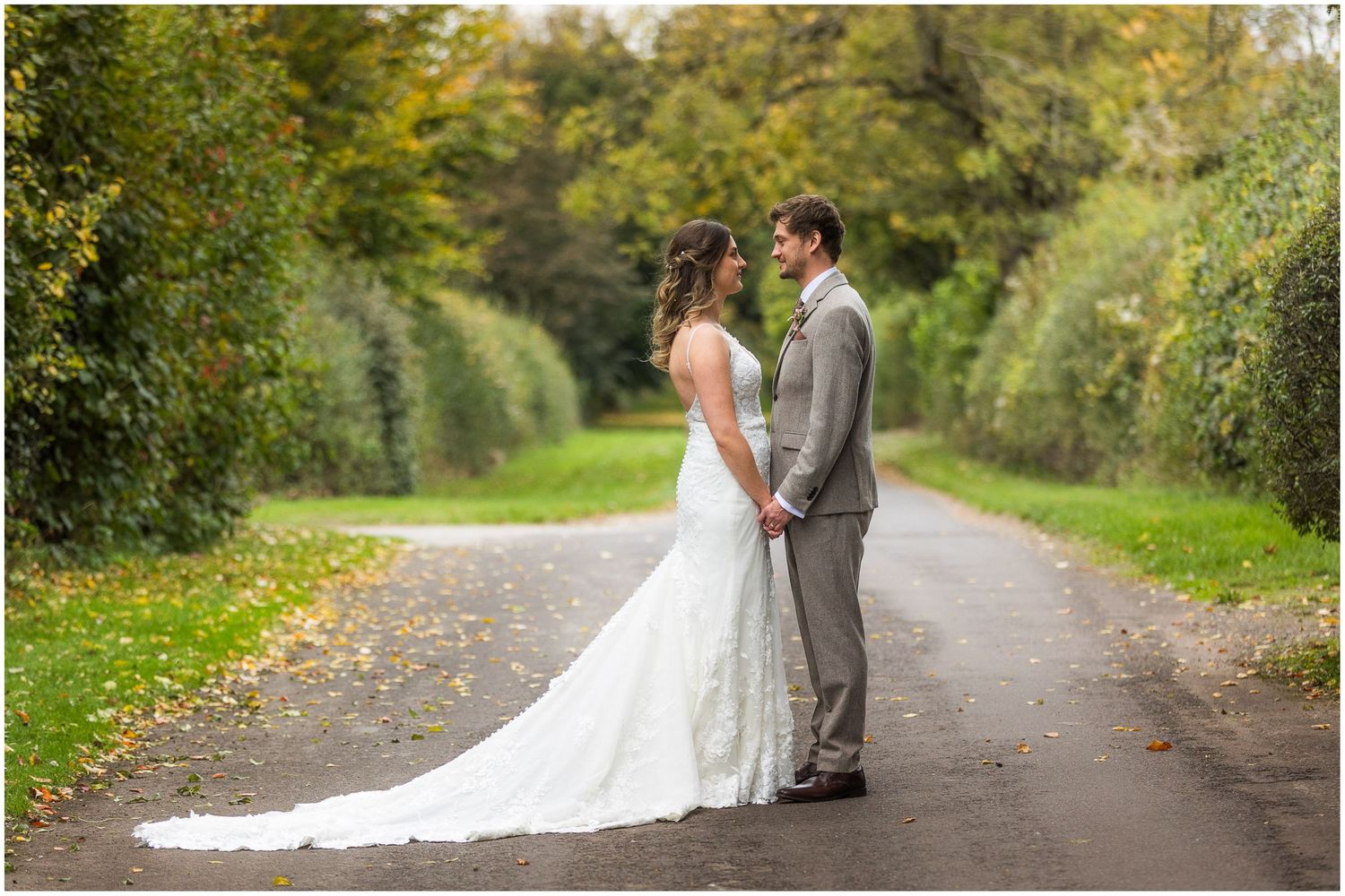 Wedding couple portrait on the long drive at Clock Barn in Hampshire