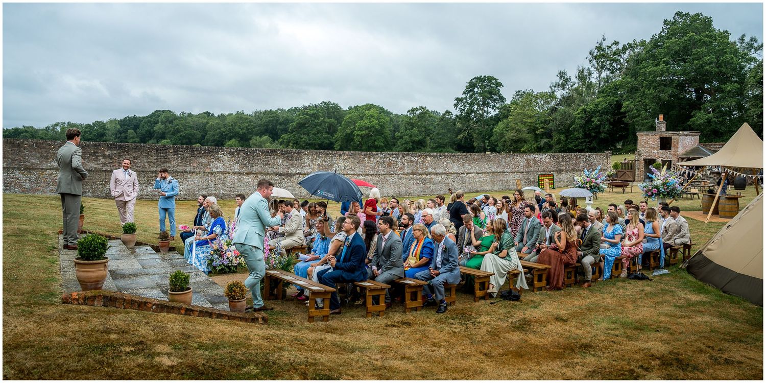 Wedding guests seating for an outdoor marriage ceremony in the walled garden of the Holywell Estate in Hampshire.