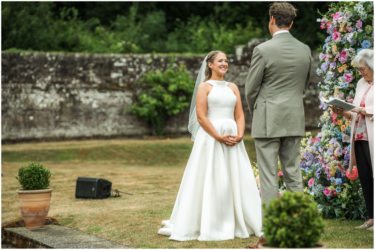 The bride and groom turn to make their vows during an outdoor garden wedding