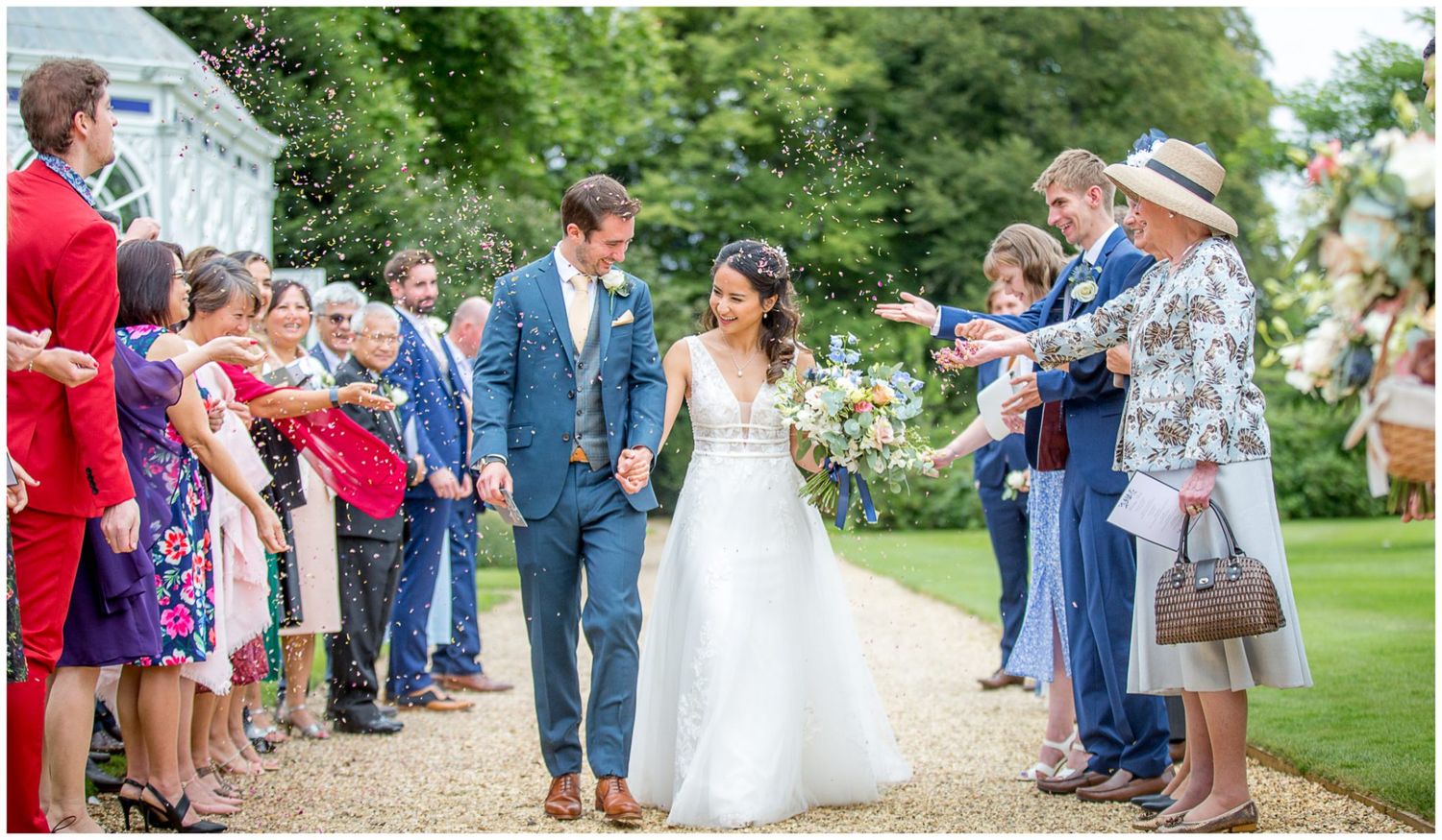 Wedding guests forming a receiving line in a beautiful garden setting.