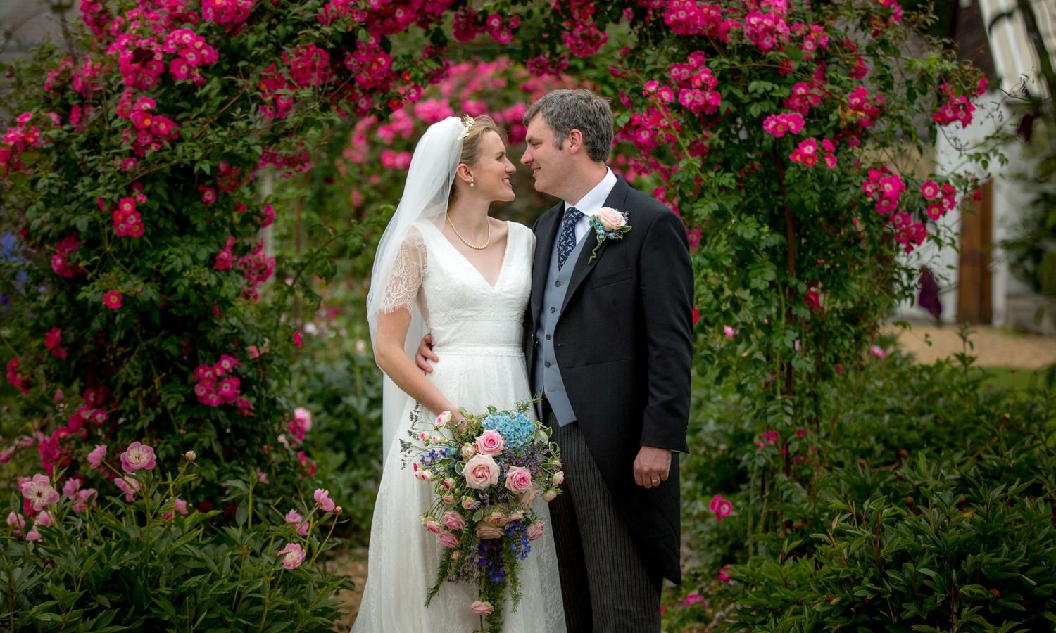Bride and groom in the rose garden at Houghton Lodge on their wedding day