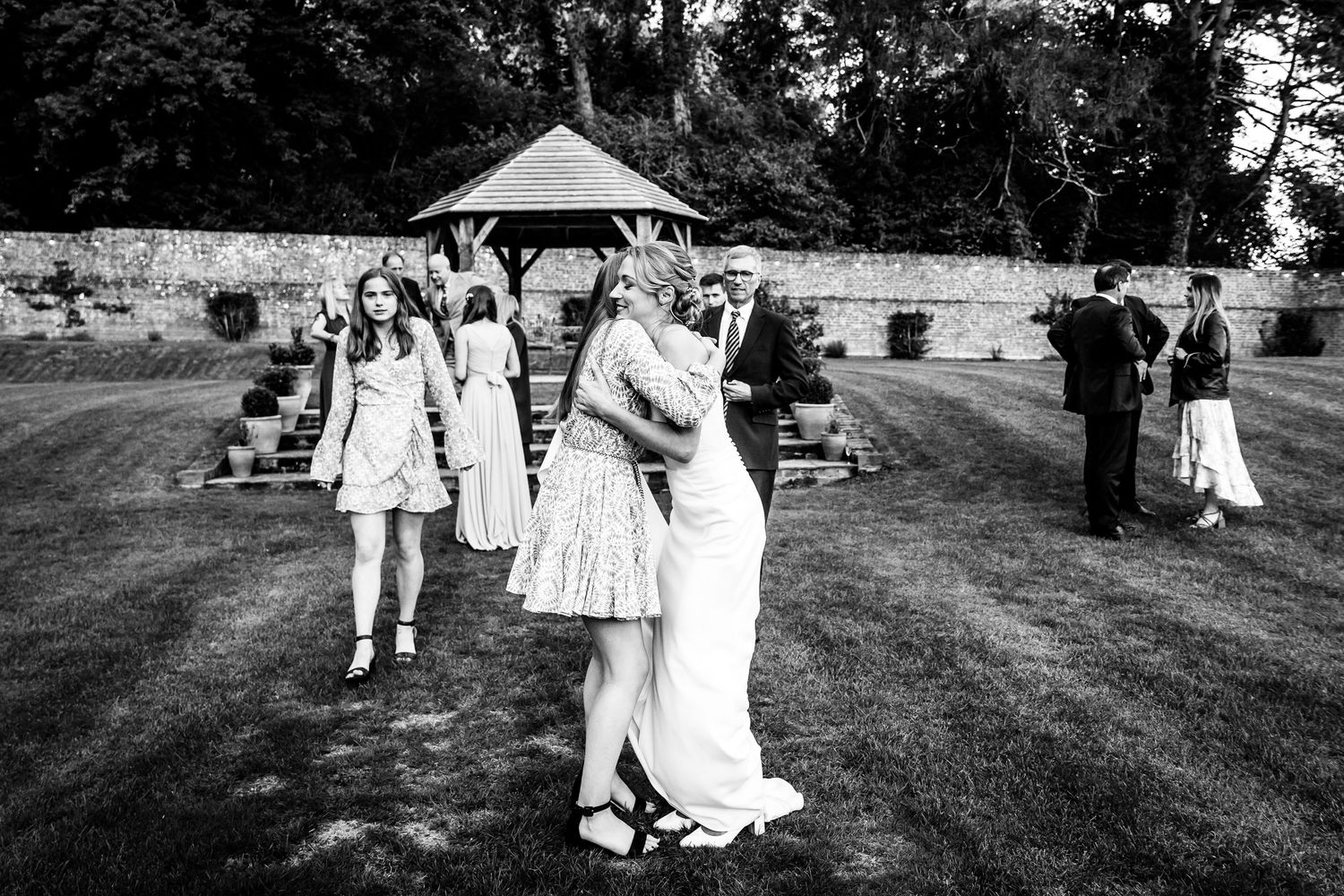 Black and white candid shots of wedding guests dancing and celebrating outdoors.