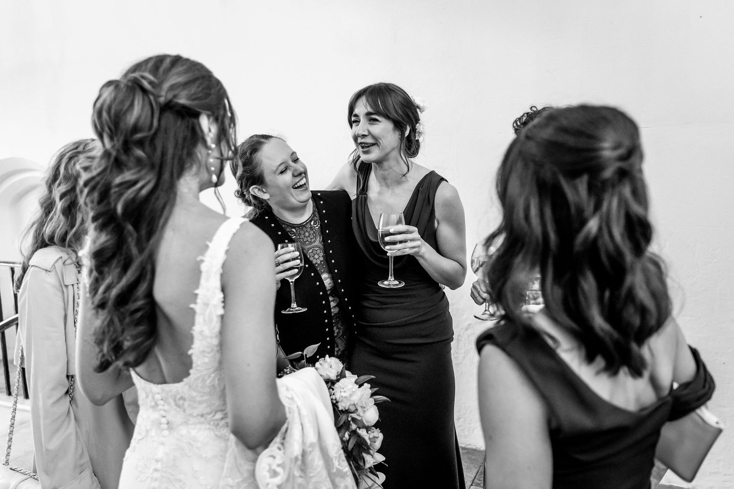 Black and white candid shots of wedding guests laughing and enjoying the celebration.