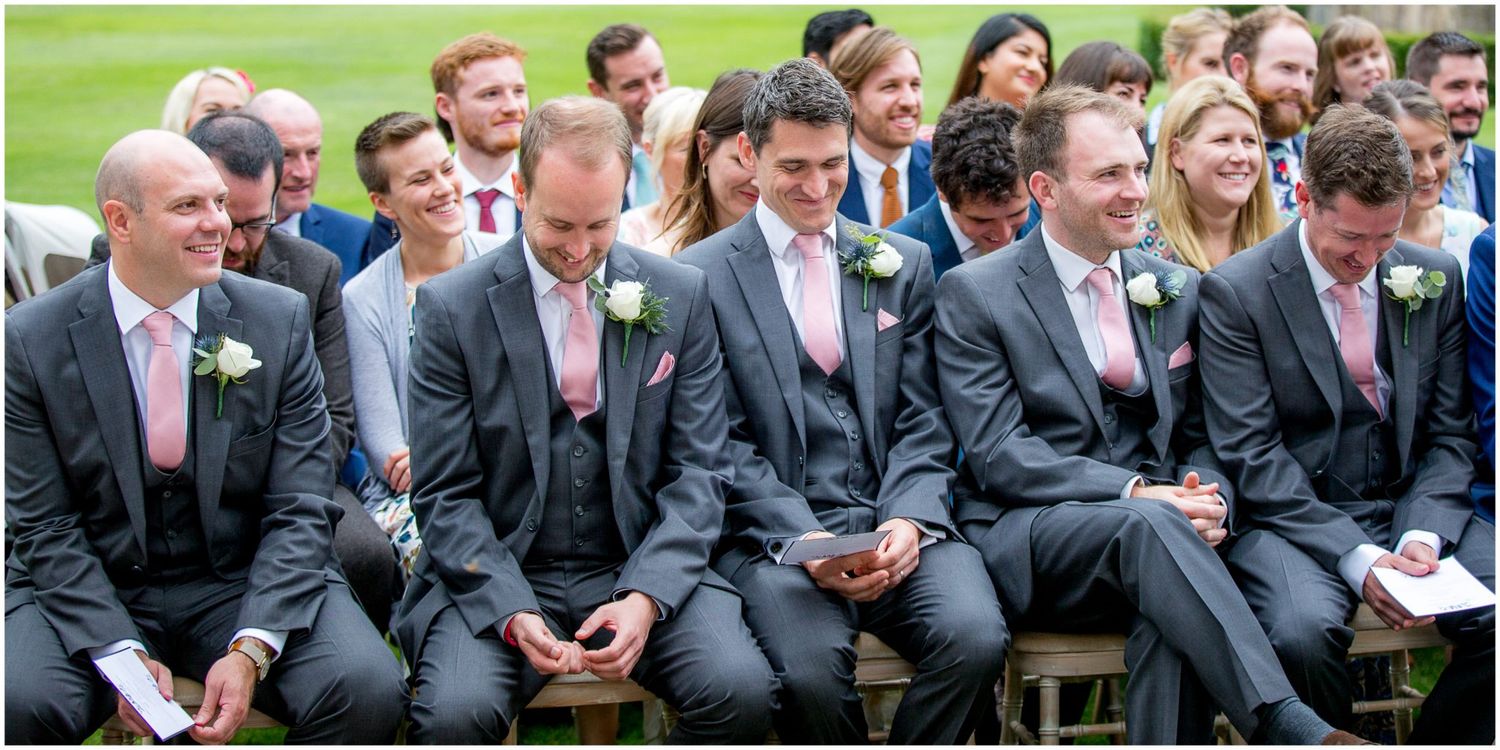 Wedding guests seated in rows during an outdoor ceremony on green grounds.