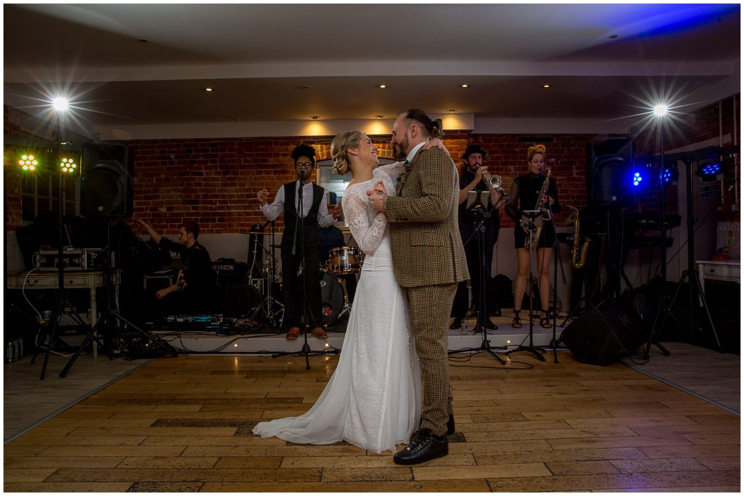 Wedding reception dance floor with colorful lighting and guests celebrating.