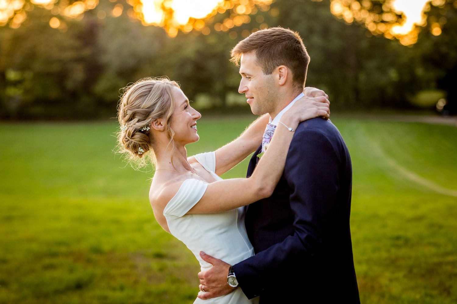 Couple embraces during sunset in a lush garden setting at their wedding.
