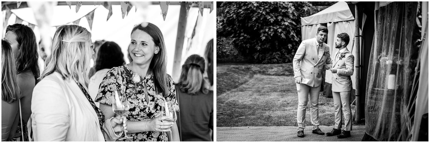 Black and white photography of wedding guests by the marquee at the Holywell Estate in Hampshire