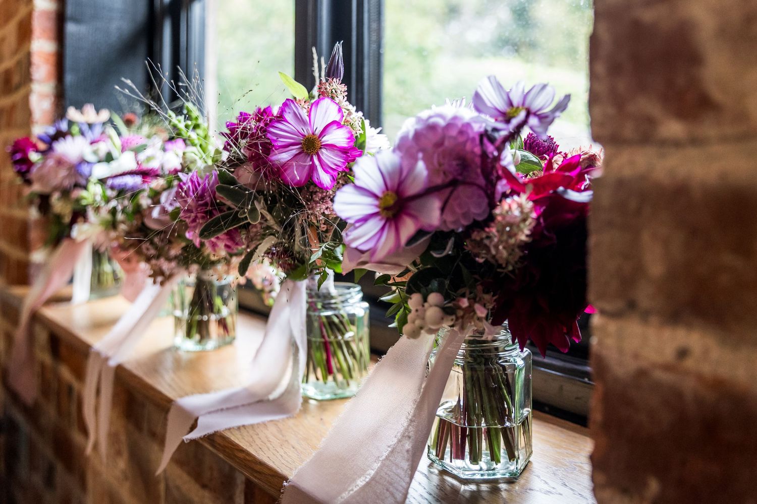 Wedding flowers photographed on the windowsill of the bride's dressing room at Clock Barn
