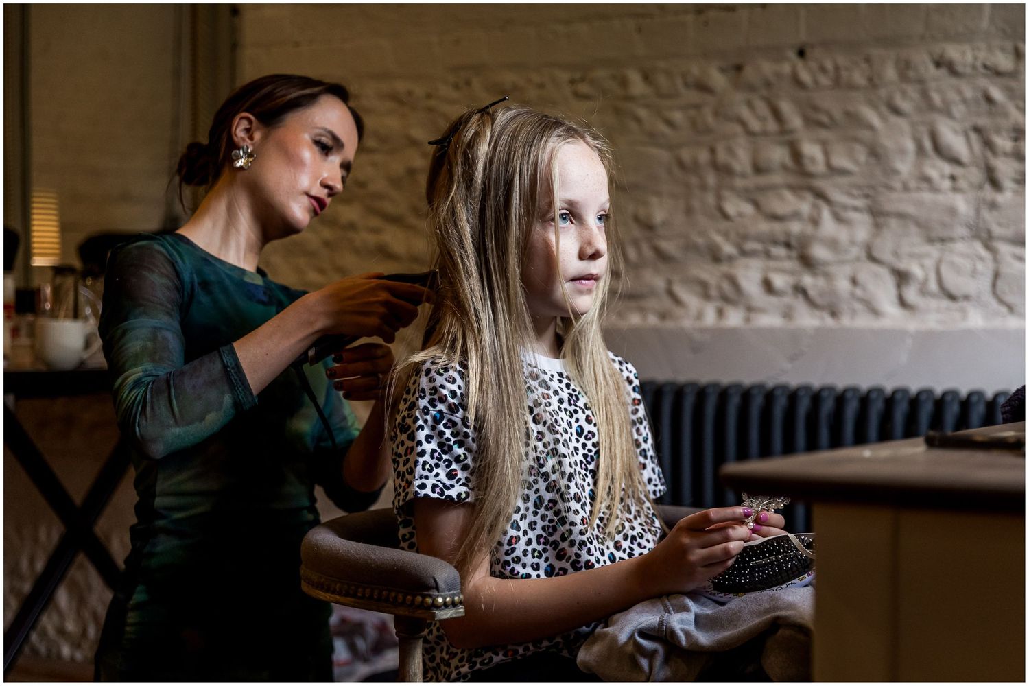Flower girl getting ready with hair and makeup in the dressing room at Clock Barn
