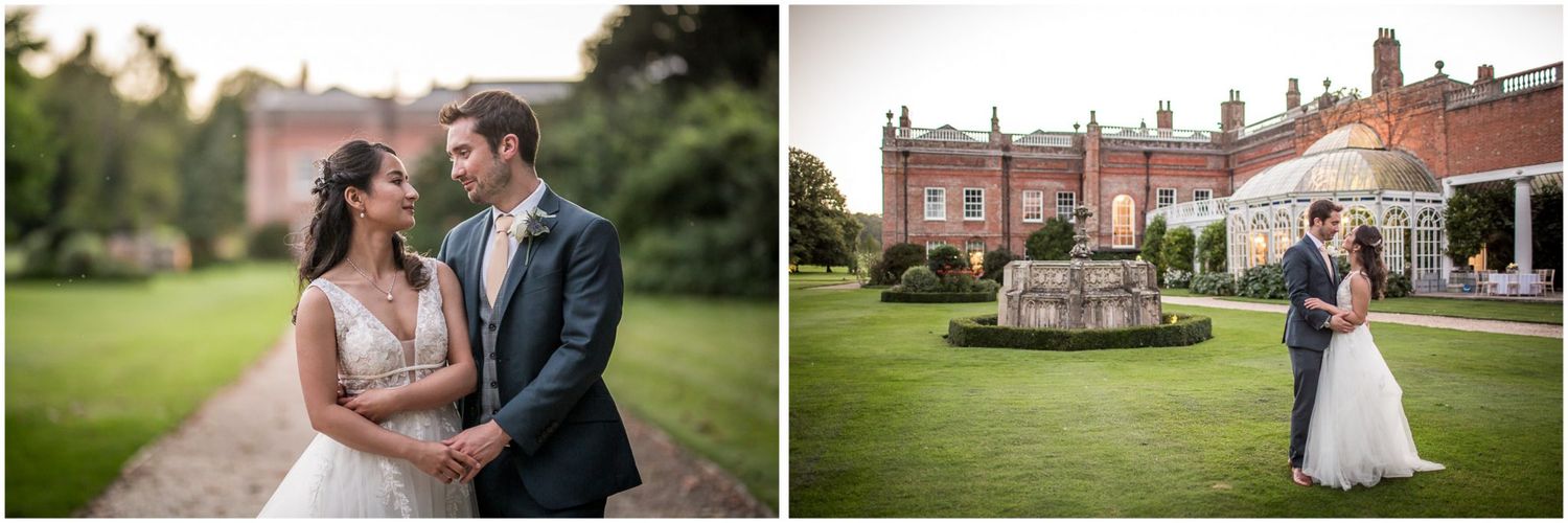 Wedding party poses in front of historic brick mansion with manicured gardens.