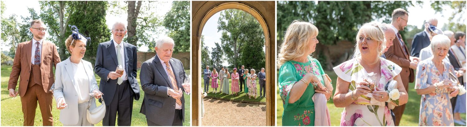 Wedding guests enjoy an outdoor celebration at a rustic garden venue with greenery and archway decorations.
