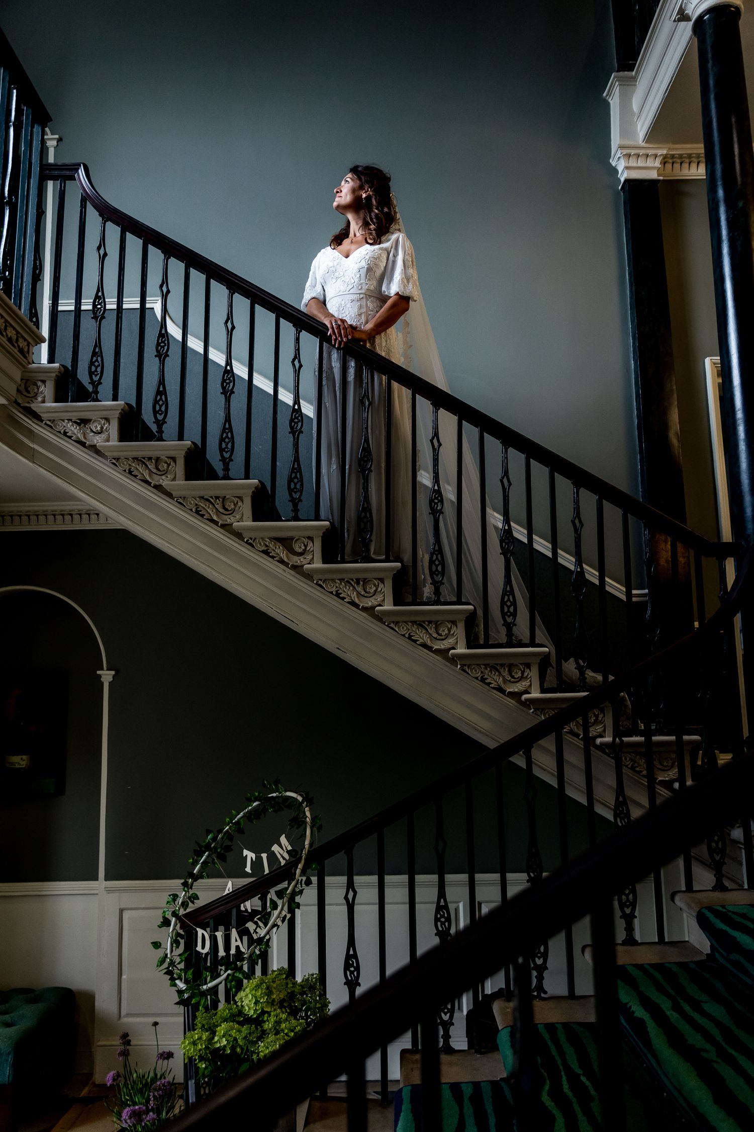 Dramatic staircase photo with elegant banister and moody lighting.