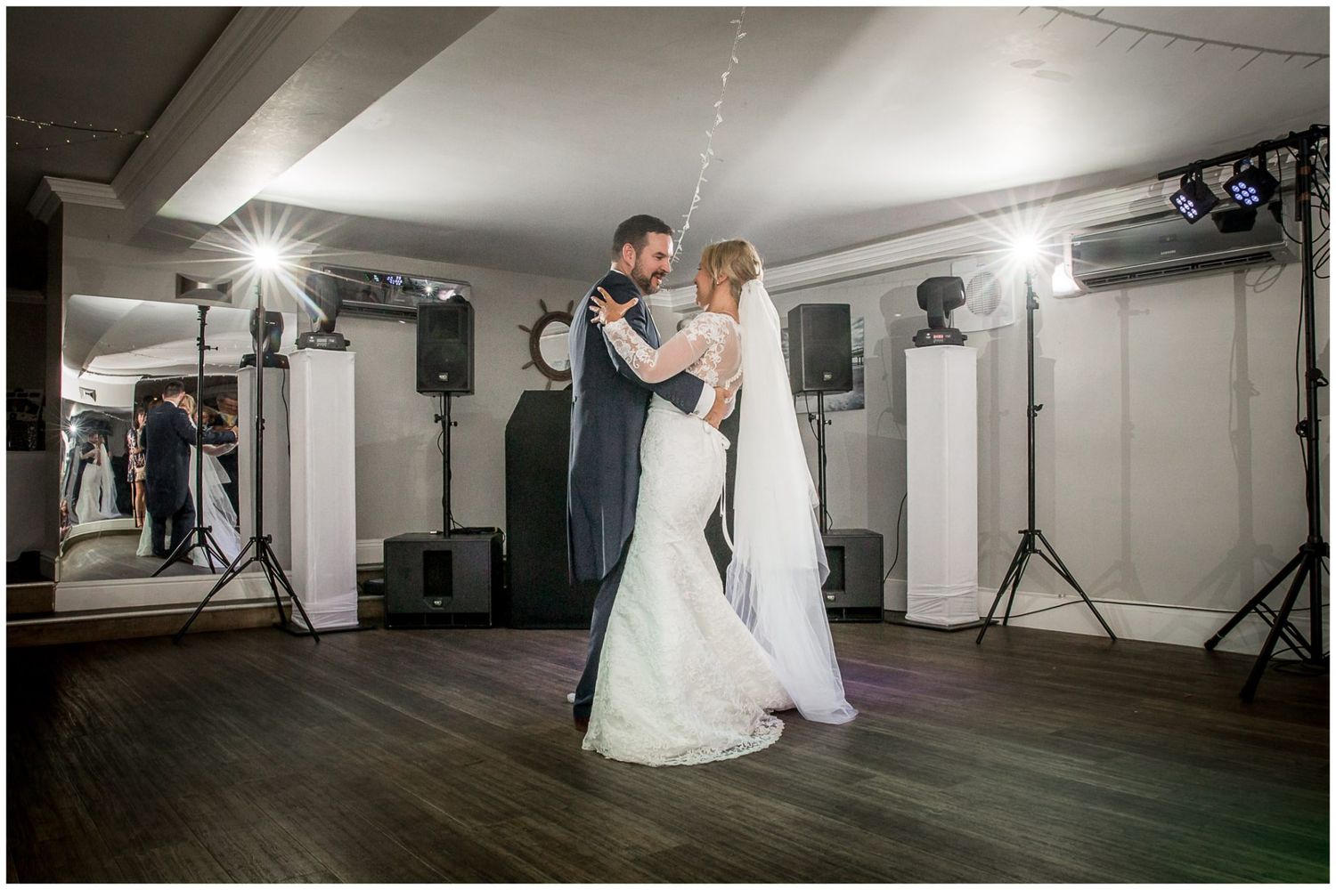 Professional studio lighting equipment setup with dance floor and white backdrop for wedding photography session.
