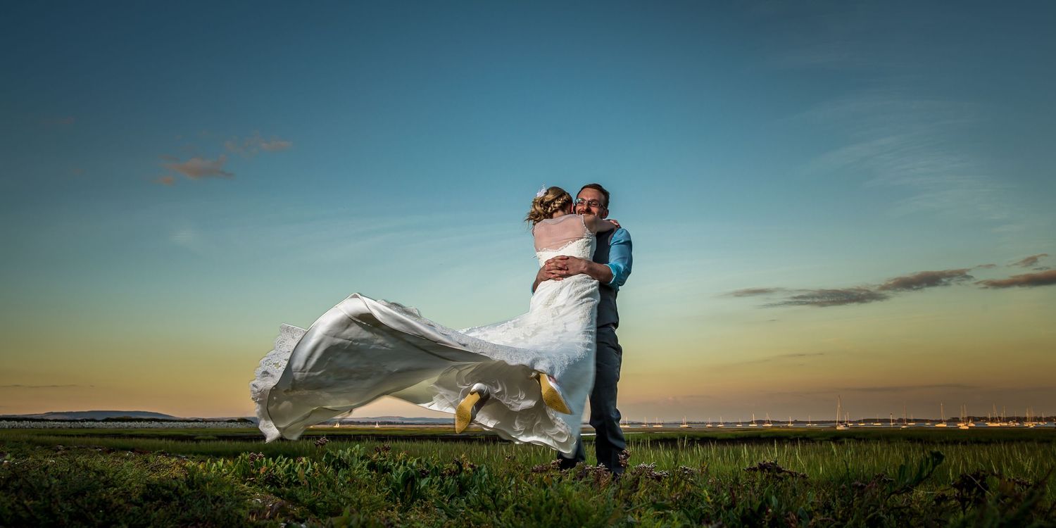 Dramatic sunset silhouettes against rural landscape with flowing fabric in wind.