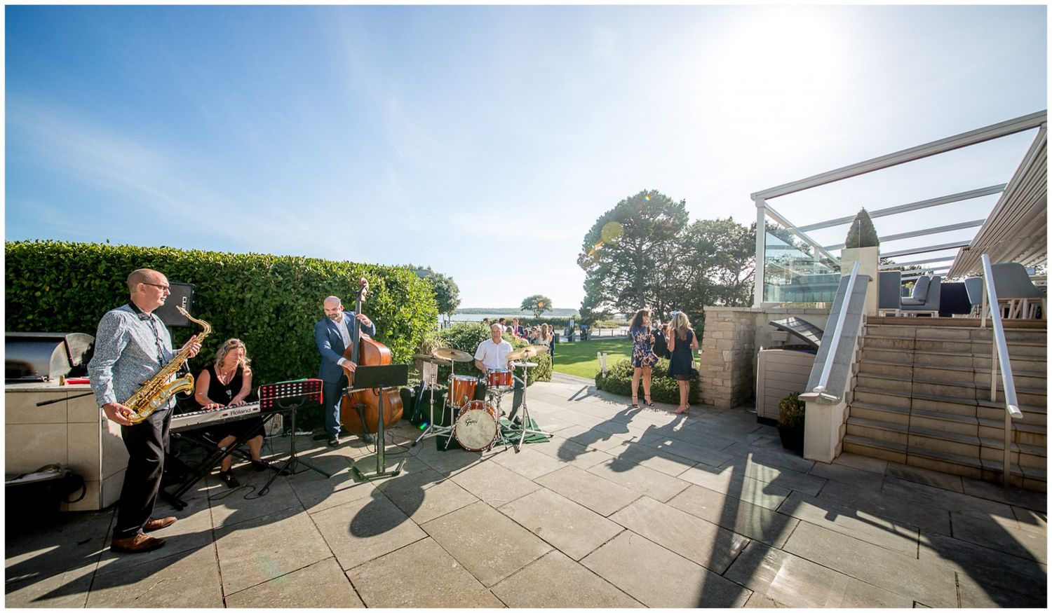 A panoramic sequence of images showing people enjoying an outdoor deck area with scenic mountain views in the background.